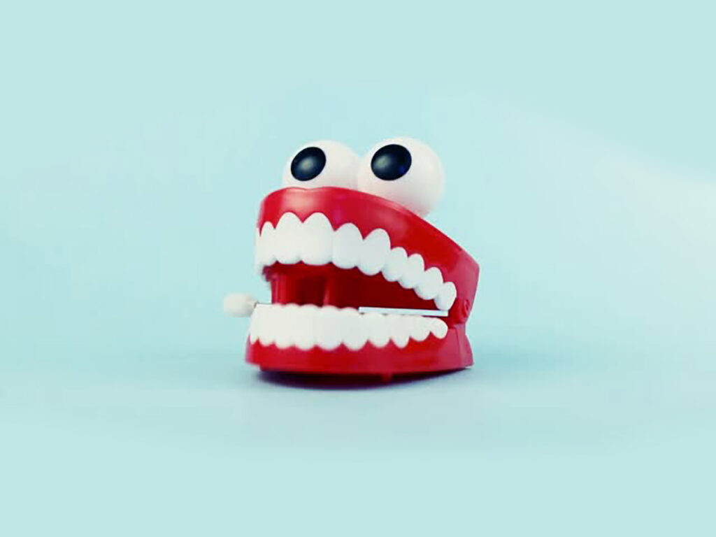 Сhattering teeth toy on blue background.